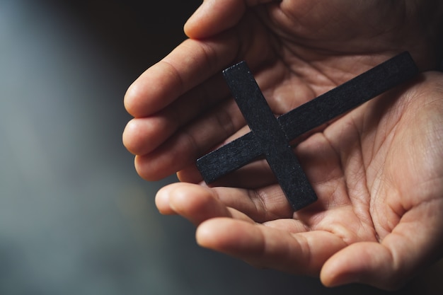 Kruzifixkreuz im Handhintergrund.
