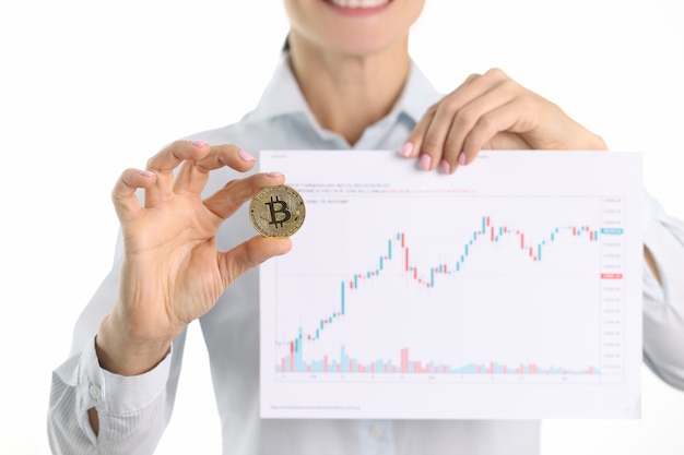 Kryptowährungsberater hält Bitcoin und Grafik mit Finanzindikatoren in den Händen top