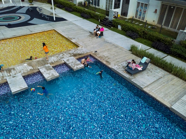 Kuala Lumpur Malasia 20 FEB 2018 Una familia feliz juega en la piscina del condominio