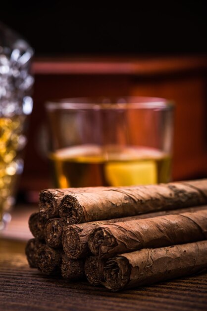 Kubanische Zigarren auf Holztisch mit Humidor und Cognac