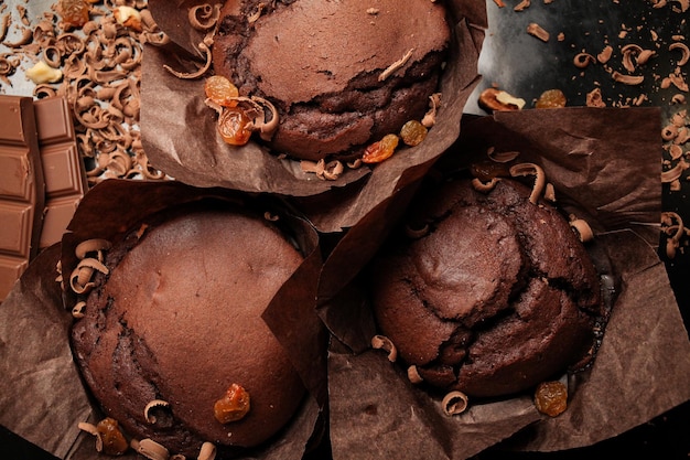 Kuchen aus schokoladen-fondant-kuchen-muffins mit walnüssen und dunklen schokoriegeln auf dunklem hintergrund