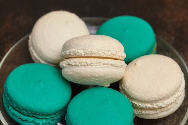 Kuchen Macaron oder Makrone auf brauner Wand, Mandelkekse