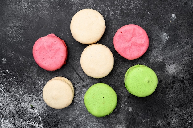 Kuchen-Macaron oder Makronen-Set, auf schwarzem, dunklem Steintischhintergrund, Draufsicht flach