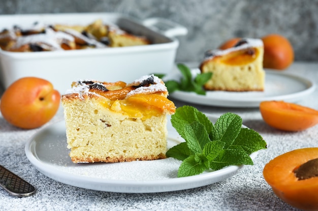 Kuchen mit Aprikosen. Hausgemachte Torte mit Pfirsichen und Aprikosen auf dem Küchentisch.