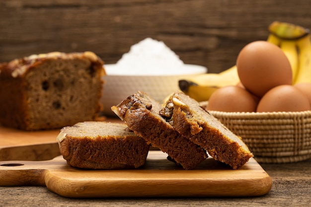 Kuchen mit Banane und Nüssen auf Holzbrett