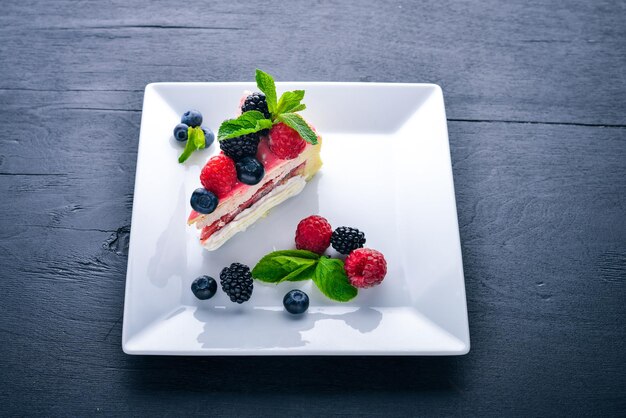 Kuchen mit Butter und frischen Beeren und Früchten Dessert Auf einem hölzernen Hintergrund Ansicht von oben Freier Platz für Ihren Text