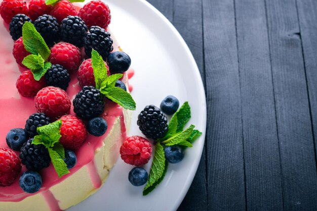 Kuchen mit Butter und frischen Beeren und Früchten. Nachtisch. Auf einem hölzernen Hintergrund. Ansicht von oben. Freiraum für Ihren Text.