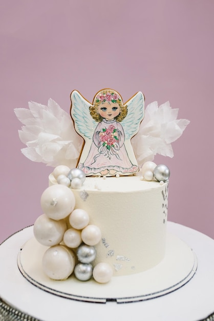 Kuchen mit einer Figur Engel dekoriert Silber und Weiß Dekor für einen Jungen oder ein Mädchen Baby-Dusche Celebration Taufe Konzept Köstlicher Empfang auf einer Geburtstagsfeier