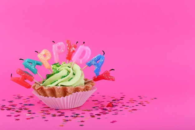 Kuchen mit Geburtstagskerzen auf rosa Hintergrund