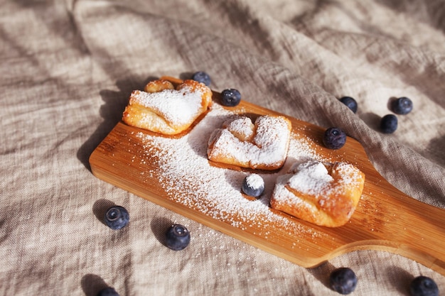 Kuchen mit Heidelbeeren, bestreut mit Puderzucker auf einem hölzernen Hintergrund Draufsicht Gesunde Ernährung Frühstücksidee für Kinder und Erwachsene