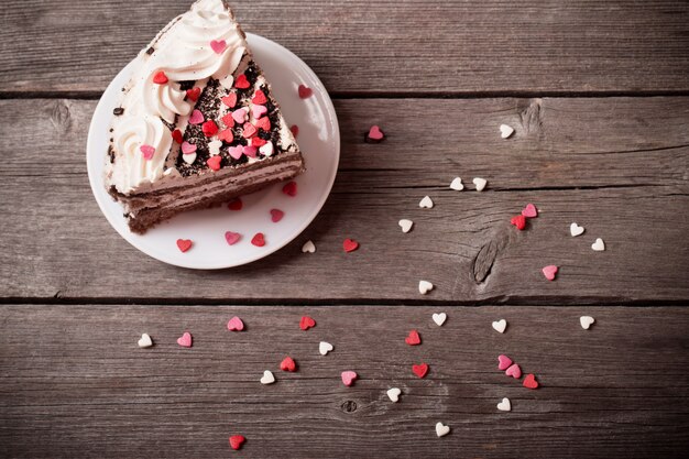 Kuchen mit Herzen auf hölzernem Hintergrund