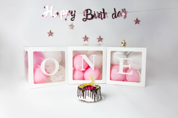 Kuchen mit Nummer eins auf dem Hintergrund von Luftballons, Geburtstagsdessert
