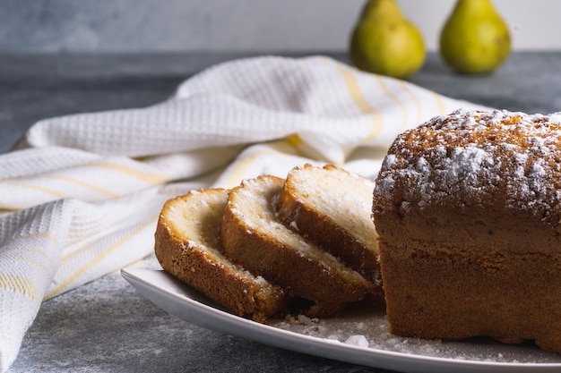 Kuchen mit Puderzucker und Birnen auf dem Tisch