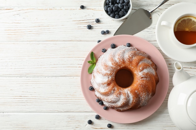 Kuchen mit Puderzucker und Blaubeere auf hölzernem Hintergrund