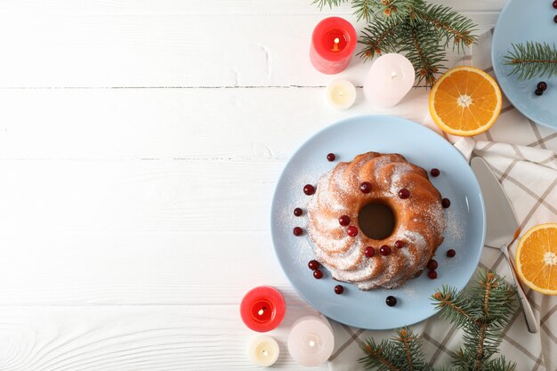 Kuchen mit Puderzucker und Cranberry auf weißem Tisch