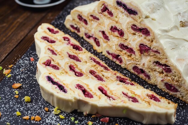 Foto kuchen mit sahne und kirschen und eine tasse kaffeeleckerer kuchen mit weißer cremerussischer kuchen namens monastyrskaya izba klosterhütte mit kirschen