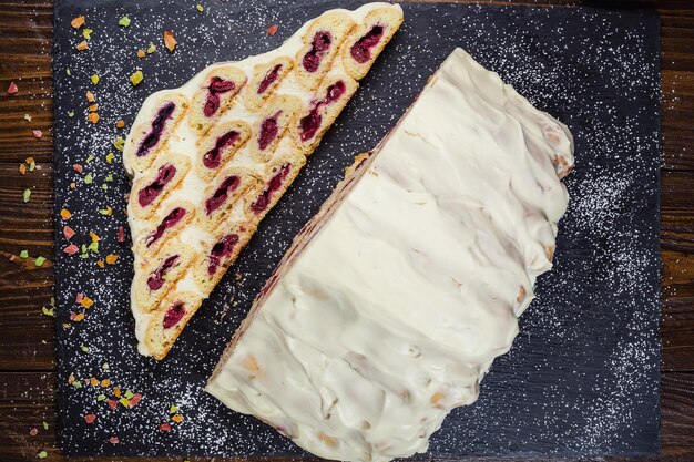 Kuchen mit Sahne und Kirschen und eine Tasse Kaffeeleckerer Kuchen mit weißer CremeRussischer Kuchen namens Monastyrskaya izba Klosterhütte mit Kirschen