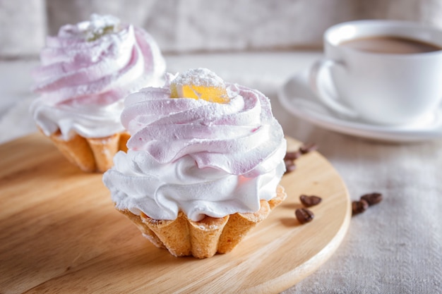 Kuchen mit Schlagsahne auf Holzbrett.