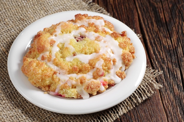 Kuchen mit Zuckerguss und Marmelade auf rustikalem Tisch