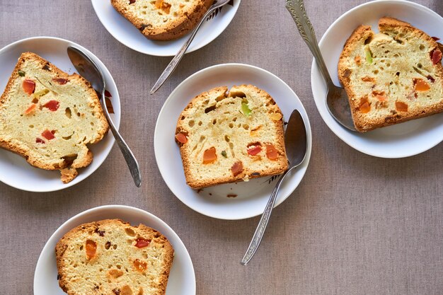 Kuchenstücke mit kandierten Früchten auf weißen Tellern