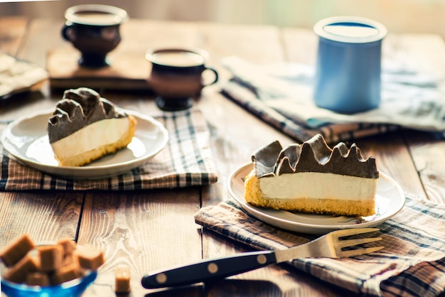 Kuchenstücke mit Sahne mit Teeset auf einem servierten Tisch