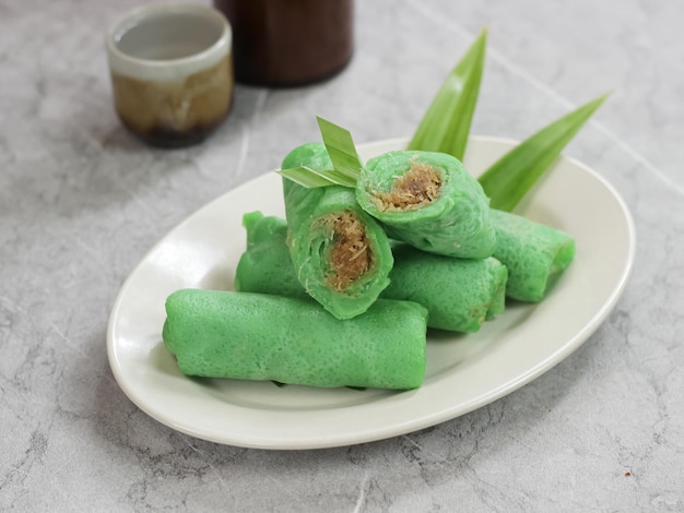 Kue Dadar gulung, uma sobremesa feita de coco de arroz glutinoso e açúcar de palma