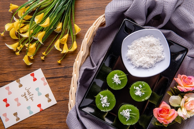 Kue Lumpang Pandan oder Kue Ijo Kue Ijo ist ein traditioneller grüner Kuchen und ist klein gedämpft und hat eine gummiartige Textur, die mit geriebener Kokosnuss serviert wird