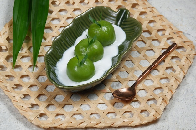 kue putri mandi ou badak berendam são bolinhos de arroz glutinoso cozidos no vapor cheios de açúcar mascavo de coco