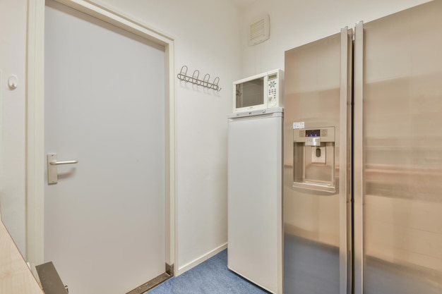 Küchenbereich mit Kühlschrank, Mikrowelle und Tür