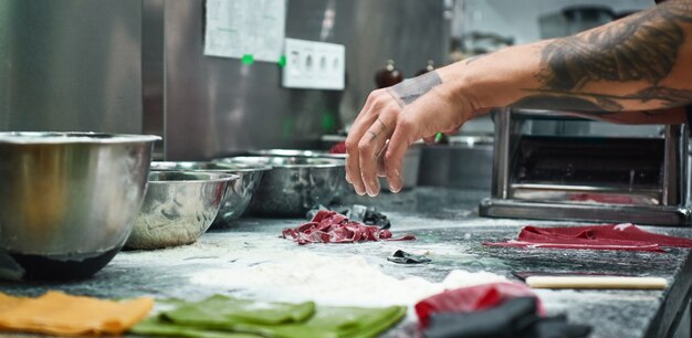 Küchenchef Hände mit Tattoos machen traditionelle italienische Pasta in der Restaurantküche