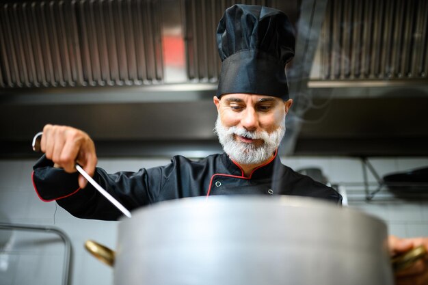 Küchenchef kocht eine Suppe in einem großen Topf