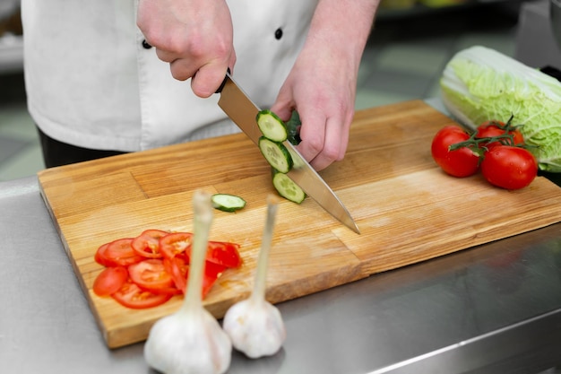 Küchenchef schneidet frisches und leckeres Gemüse für einen Gemüsesalat