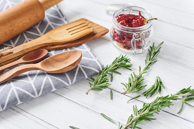 Küchengeräte und Kochen von Bestandteilen auf einem weißen hölzernen Hintergrund, Draufsicht