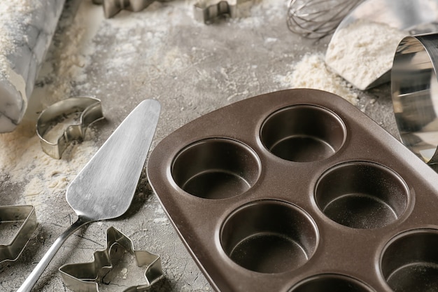 Küchenutensilien zur Zubereitung von Bäckerei und Mehl auf dunklem Hintergrund