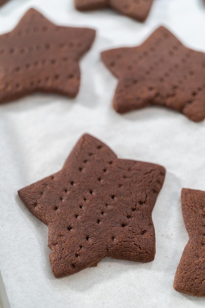 Kühlen Sie frisch sternförmig gebackene Schokoladen-Graham-Cracker auf dem mit Pergamentpapier ausgelegten Backblech ab.