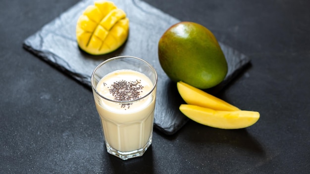 Kühler Mango-Milchshake auf schwarzem Hintergrund ein Getränk, um Ihren Durst in der indischen Sommerküche zu stillen