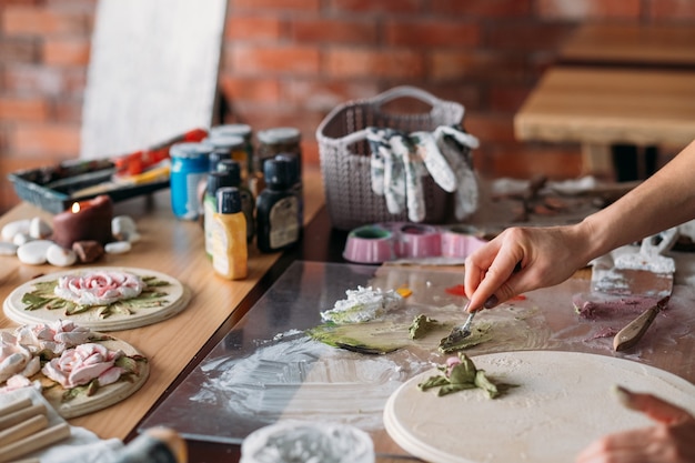 Künstler Arbeitsplatz. Inspiration. Handwerkliche Fähigkeiten. Frau mit Modellierungswerkzeugen, die im Studio arbeiten. Kreative Atmosphäre.