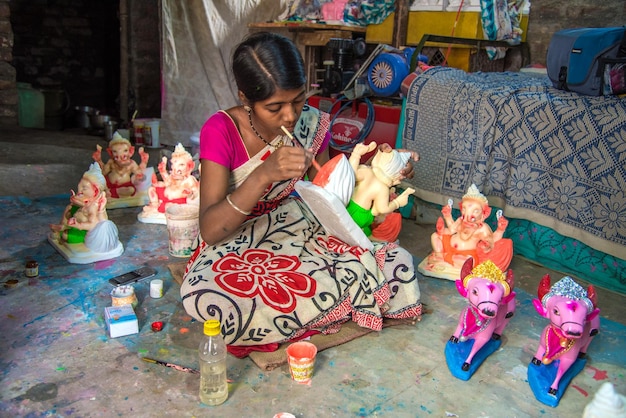 Künstler, der eine Statue herstellt und einem Idol des Hindu-Gottes Lord Ganesha in einem Artist39s-Workshop für das Ganesha-Festival den letzten Schliff gibt