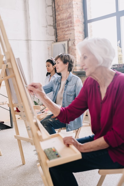 Künstler sitzen in Reihe im Kunststudio