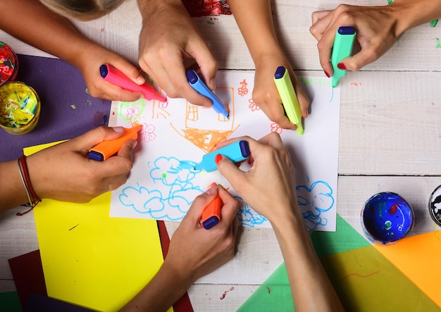 Künstlerholztisch mit Farben und farbigem Papier