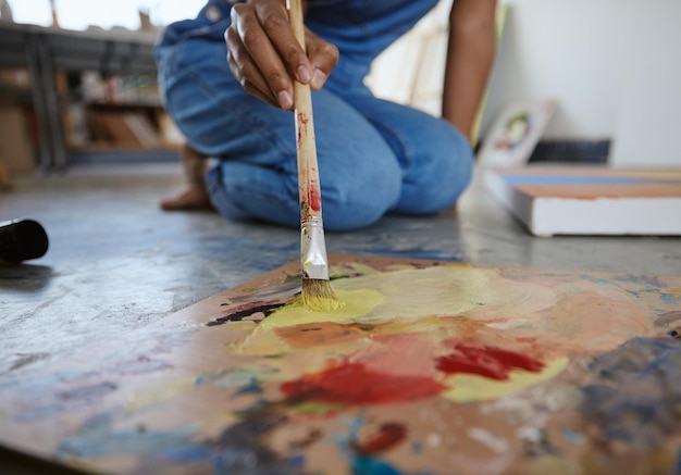 Künstlerin malt und malt Pinsel auf dem Boden des Kunststudios, kreativ zu sein und mit Aquarell für Kunstwerke zu arbeiten Talentierte Fähigkeiten und Leinwand in Nahaufnahme mit der Hand einer Malerin in der Werkstatt