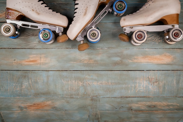 Künstlerische Rollschuhe auf einem hölzernen Hintergrund