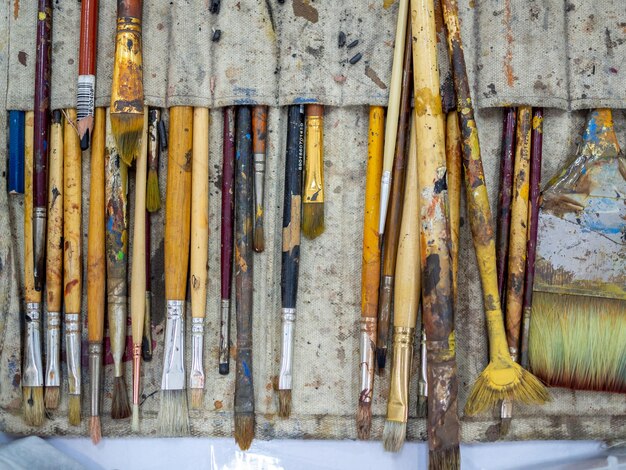 Künstlerpinsel-Set Flache Lage vieler Künstlerwerkzeuge in Kaliko-Pinselhalter