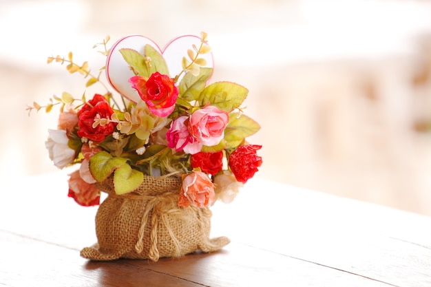 Künstliche Blumen auf Holztisch