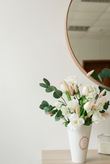 Künstliche Blumen in einer Vase auf dem Hintergrund des Spiegels