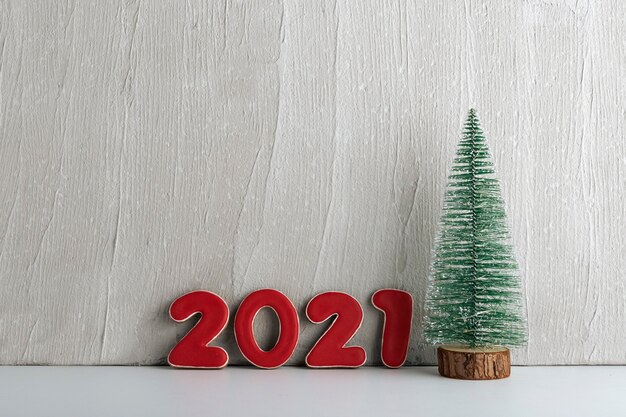 Künstlicher Weihnachtsbaum und rote Zahlen 2021. Neujahrskonzept. Speicherplatz kopieren.