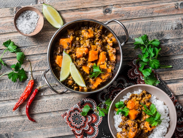 Kürbis-Linsen-Curry und Reis auf einem Holztisch Draufsicht Indisches vegetarisches Essenskonzept