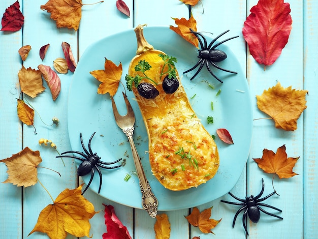 Kürbis mit gelben Blättern auf blauem Hintergrund Lustiger Halloween-Hintergrund