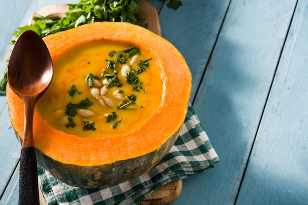 Foto kürbis- und karottensuppe auf blauem holztisch. herbst essen.