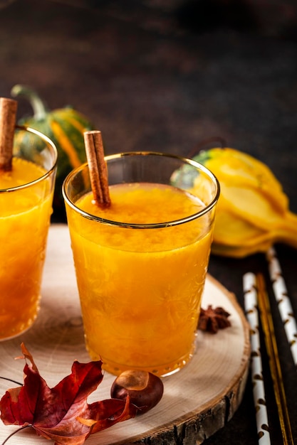 Kürbiscocktail mit Herbstdekor auf Holztisch.